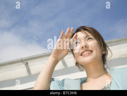 Frau, die Augen vor Sonne Abschirmung Stockfoto
