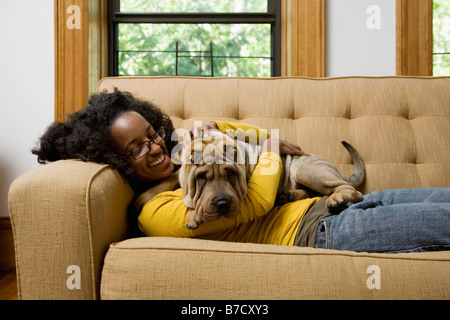 Eine Frau liegt eine Couch mit ihren Shar-Pei Stockfoto