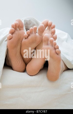 Ein paar Füße im Bett liegend Stockfoto