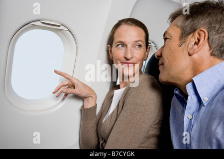 Ein paar schaut aus dem Fenster eines Flugzeugs Stockfoto