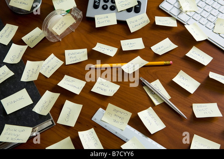 Ein Schreibtisch, vollgestopft mit Erinnerungen geschrieben am Klebstoff Notizen Stockfoto