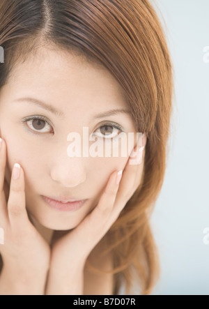 Woman holding face in hands Stockfoto