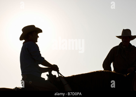 Silhouette der beiden Cowboys auf Pferden sitzend Stockfoto