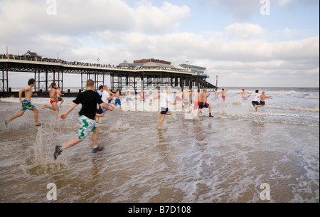 Schwimmer läuft in das Meer am zweiten Weihnachtstag bei Cromer in Norfolk für wohltätige Zwecke Stockfoto