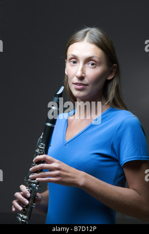 Eine junge Frau hält eine Klarinette Stockfoto