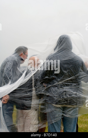 Festivalbesucher Zuflucht vor dem Regen unter Plastikplanen Hop Farm Festival Stockfoto