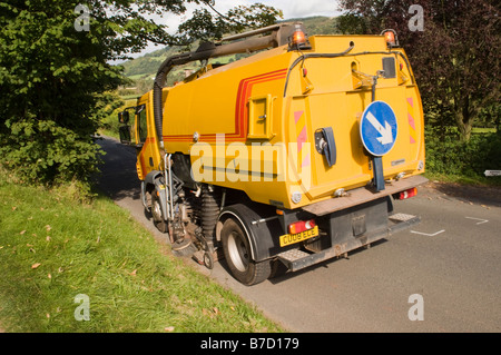 mechanische Kehrmaschine arbeitet an einer Straße Stockfoto