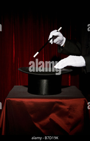 Ein Magier der behandschuhten Hände durchführen einen Zaubertrick Stockfoto