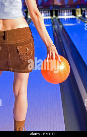 Junge Frau mit Bowling-Kugel Stockfoto