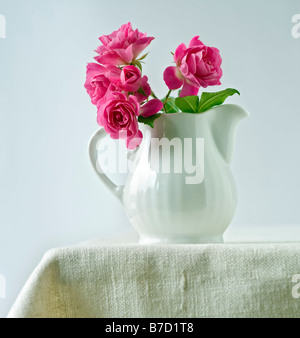 kleinen Rosenstrauß in einen Krug Keramik Milch Stockfoto