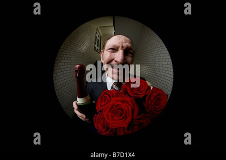 Ein Mann mit Rosen und Champagner, angezeigt durch ein Guckloch Stockfoto