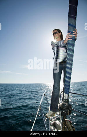 Eine Frau stand auf dem Vorschiff einer Yacht Stockfoto