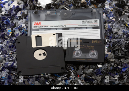 Haufen von alten Stil gemischt Magnetträger Bandkassette Dds DAT-Band und floppy-disk auf einem Bett aus geschredderten magnetische Medien Stockfoto