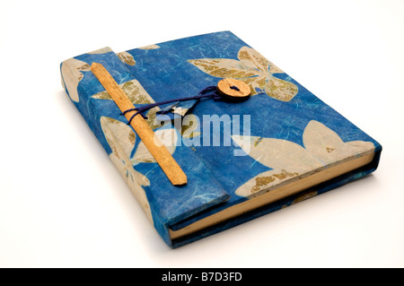 Kleine blaue Tagebuch verziert mit Blättern auf weißem Hintergrund Stockfoto