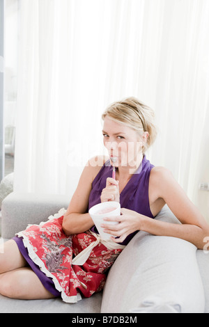 Frau auf Sofa Eis essen Stockfoto