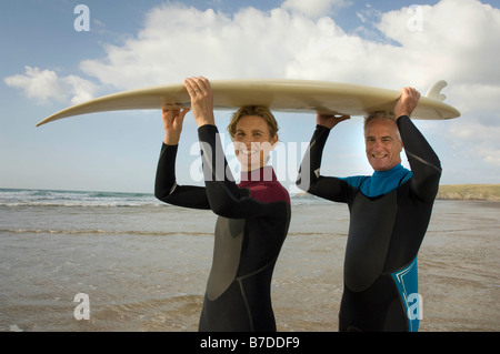 Paar mit Surfbrett am Strand Stockfoto