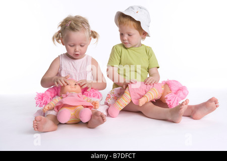 Zwei kleine Mädchen mit ihren Puppen spielen Stockfoto