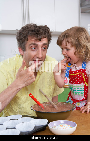 Vater und Tochter, Verkostung Teig Stockfoto