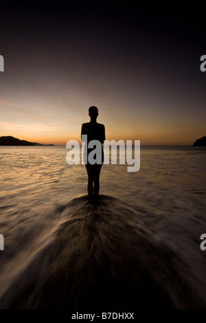 Silhouette der jungen Frau in Playas del Coco, Costa Rica Yoga am Strand bei Sonnenuntergang zu machen. Stockfoto