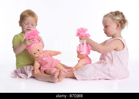 Zwei kleine Mädchen mit ihren Puppen spielen Stockfoto