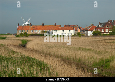 Ein Blick über Sümpfe gegenüber den Feuerstein und rotem Backstein Häuser Cley als nächstes am Meer mit Cley Mill im Hintergrund. Norfolk. VEREINIGTES KÖNIGREICH. Stockfoto