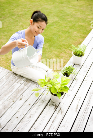Frau Bewässerung Pflanzen Stockfoto
