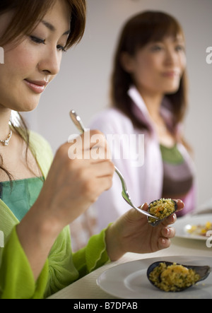 Frau mit Ofen gebratene Muscheln Stockfoto