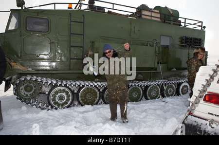 Eisfischen für Sud vor modifizierten Tank (Vezdekhod), Anadyr Tschukotka, Sibirien-Russland Stockfoto