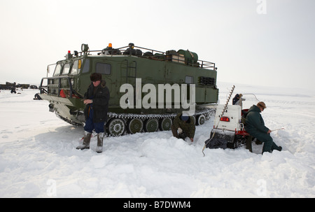 Eisfischen für Sud vor modifizierten Tank, (Vezdekhod) Anadyr Tschukotka, Sibirien-Russland Stockfoto