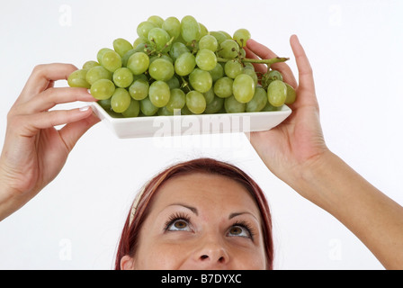 junge Frau mit Trauben Stockfoto