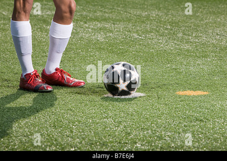 Beine eines Fußballer und Fußball Stockfoto