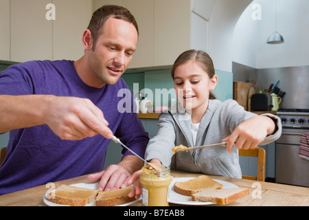 Vater und Tochter machen sandwiches Stockfoto