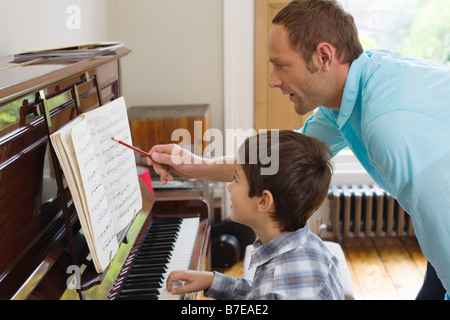 Vater Sohn beizubringen, wie man Klavier spielen Stockfoto