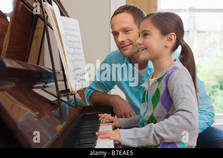 Vater Tochter beizubringen, wie man Klavier spielen Stockfoto