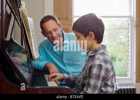 Vater Sohn beizubringen, wie man Klavier spielen Stockfoto