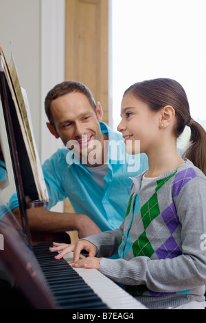 Vater Tochter beizubringen, wie man Klavier spielen Stockfoto