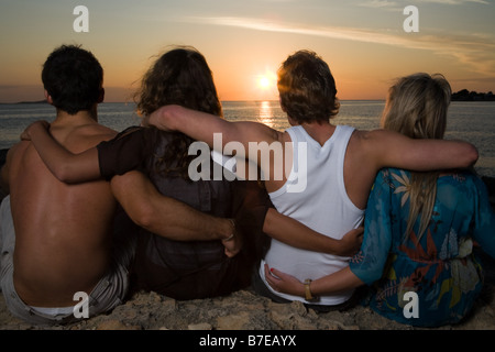 Freunde, die den Sonnenuntergang auf dem Seeweg Stockfoto