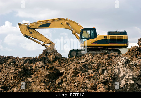 Eine Baustelle mit einem großen Bagger geparkt auf einem großen Berg von Schmutz Stockfoto