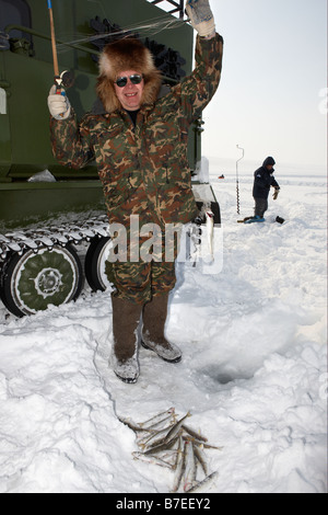 Eisfischen für Sud vor modifizierten Tank (Vezdekhod), Anadyr Tschukotka, Sibirien-Russland Stockfoto