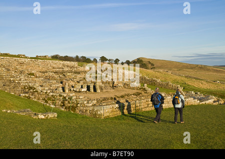 dh Housesteads HADRIANS WALL NORTHUMBRIA Touristenwanderer betrachten Vercovicivm Römisches Fort Northumberland National Park Menschen wandern im Winter Stockfoto