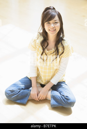 Eine Frau sitzt im Schneidersitz Stockfoto