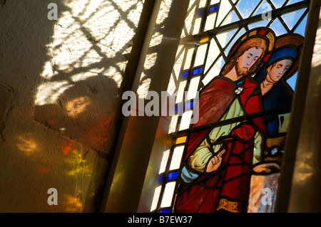 Tageslicht strömt durch eine englische Kirche Buntglasfenster Darstellung Jesu Christi Stockfoto