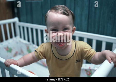 Glückliches Babymädchen in ihrem Bettchen Stockfoto