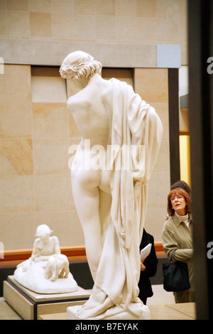 Eine Frau schaut "Narcisse" (1867) von Paul Dubois in der Kunstgalerie Musee d ' Orsay, Paris, Frankreich Stockfoto