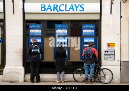 Drei Kunden, die ein Barclays-Loch in der Wand-Maschine (atm) in der Niederlassung in Cornmarket Street, Oxford. Jan 2009 Stockfoto