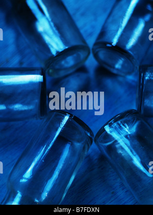 Kleines Glas-Medizin-Flaschen auf blauem Hintergrund. Stockfoto