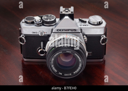 Olympus OM2n single Lens reflex 35mm-Kamera mit 50mm f1 8 Zuiko Objektiv Darkwood Hintergrund Stockfoto