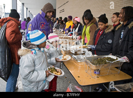 Freiwillige dienen Essen an die Obdachlosen in Outdoor-Suppenküche Stockfoto