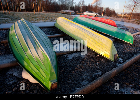 Vier Fiberglas Ruderboote / Skiffs / Dinghy / Schlauchboote, umgedreht für die Winterlagerung, sind mit Frost bedeckt, Finnland Stockfoto