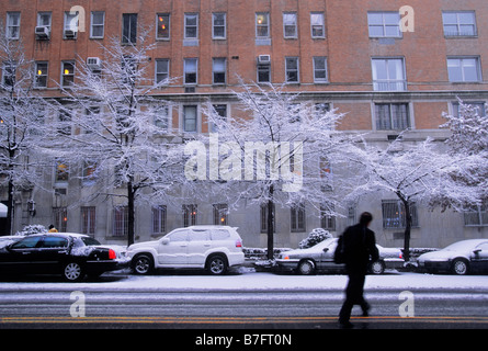 New York City East End Avenue. Winterschneesturm im Appartementhaus. Mann überquert die schlüpfrige 79. Straße. USA Stockfoto